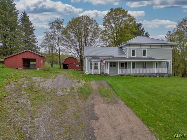 1957 Torpy Pond Rd, Georgetown, NY 13061 - view of front facade featuring dirt driveway, an outbuilding, a porch, a front lawn, and metal roof
