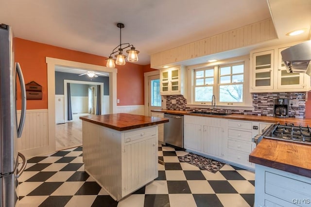 1957 Torpy Pond Rd, Georgetown, NY 13061 - kitchen featuring wooden counters, a sink, appliances with stainless steel finishes, light flooring, and a wainscoted wall