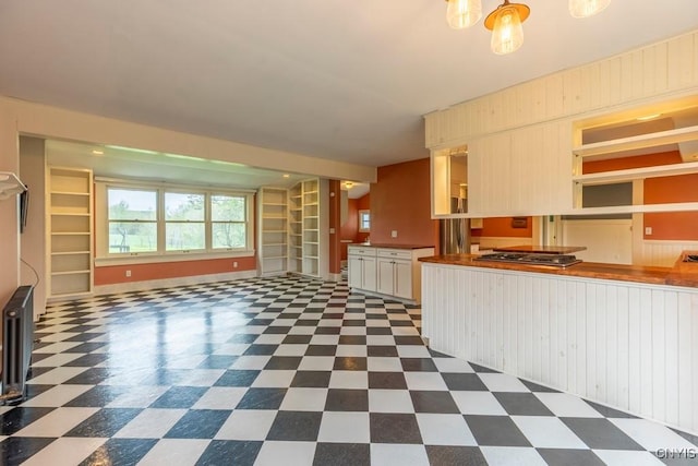 1957 Torpy Pond Rd, Georgetown, NY 13061 - kitchen featuring dark floors, stainless steel gas cooktop, open shelves, built in features, and open floor plan