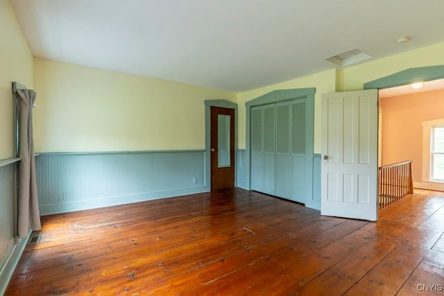 1957 Torpy Pond Rd, Georgetown, NY 13061 - unfurnished bedroom featuring hardwood / wood-style flooring, a wainscoted wall, a closet, and baseboards