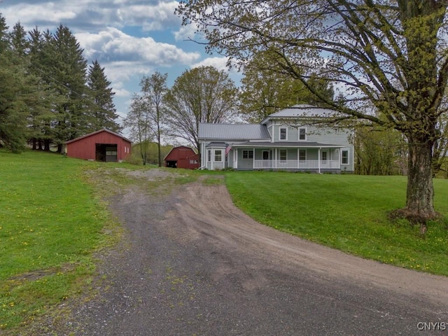 1957 Torpy Pond Rd, Georgetown, NY 13061 - view of front facade featuring an outbuilding, a front yard, dirt driveway, and covered porch