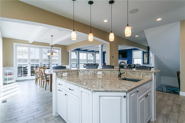 5088 E Lake Rd, Gorham, NY 14544 - kitchen featuring a sink, open floor plan, light wood-type flooring, arched walkways, and white cabinets