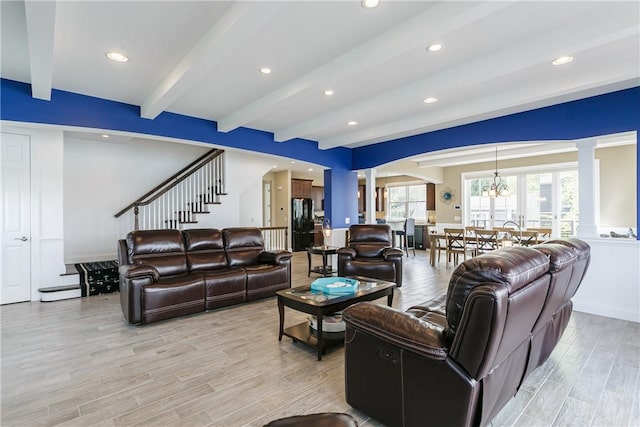 5088 E Lake Rd, Gorham, NY 14544 - living area with ornate columns, beamed ceiling, light wood-style flooring, a chandelier, and stairway