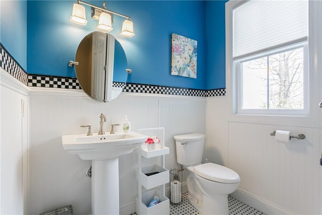 5088 E Lake Rd, Gorham, NY 14544 - half bath featuring toilet, a wainscoted wall, a decorative wall, and a sink