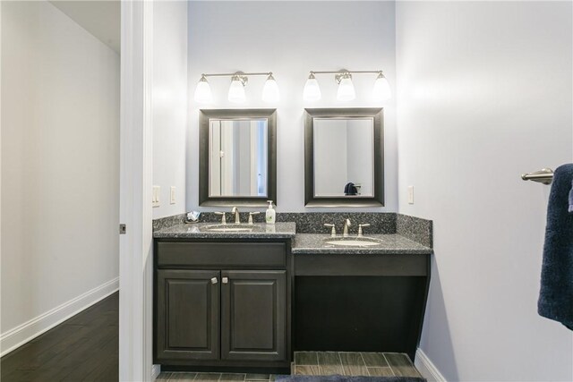 5088 E Lake Rd, Gorham, NY 14544 - bathroom featuring baseboards, double vanity, and wood finished floors
