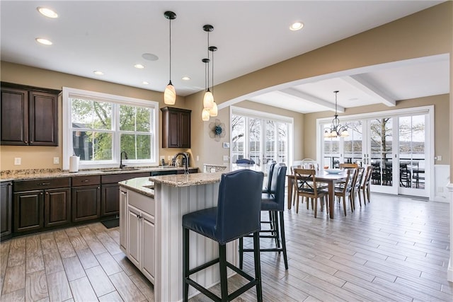 5088 E Lake Rd, Gorham, NY 14544 - kitchen featuring beamed ceiling, light wood finished floors, dark brown cabinets, recessed lighting, and light stone countertops