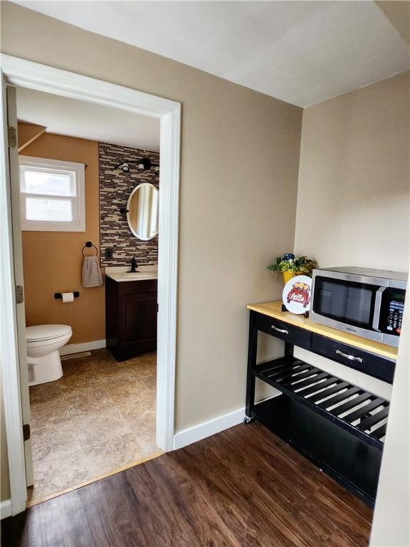 515 Park Pl, Erwin, NY 14870 - bar area with stainless steel microwave, a sink, and baseboards