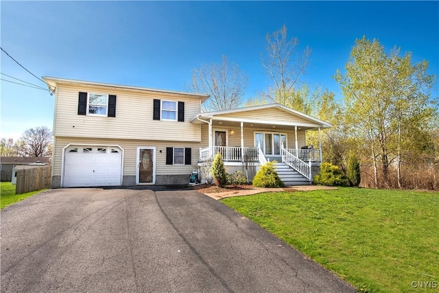 tri-level home with covered porch, a garage, a front yard, and driveway