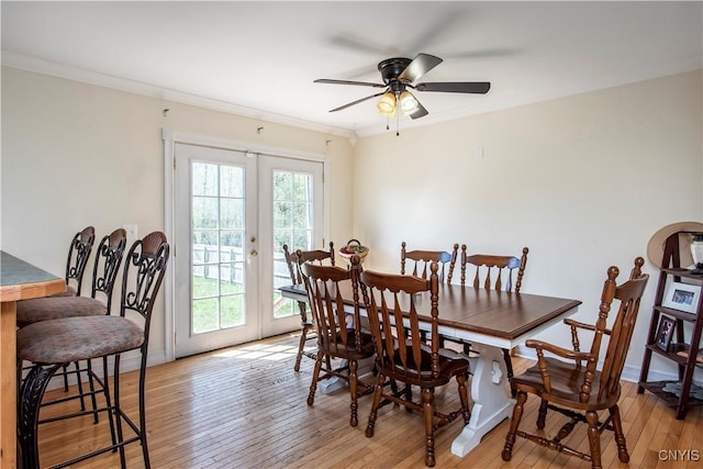 dining area featuring french doors, a ceiling fan, light wood finished floors, and ornamental molding