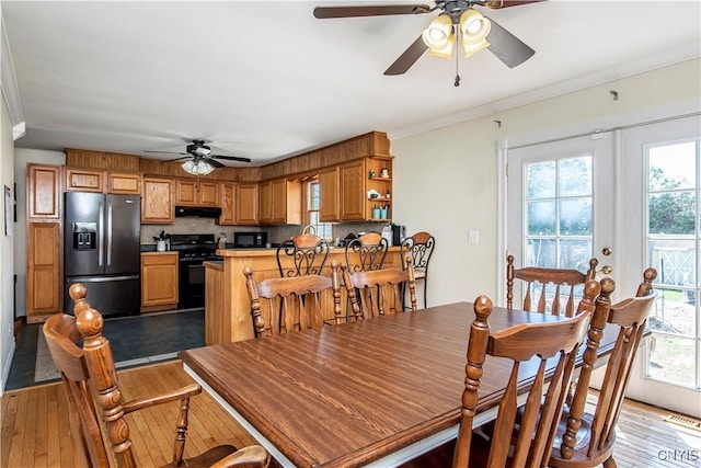 dining space with ceiling fan, healthy amount of natural light, crown molding, and wood-type flooring