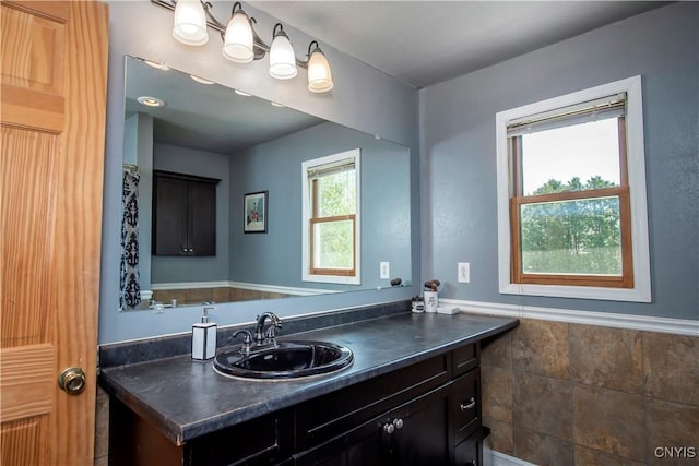 bathroom with vanity and a wainscoted wall