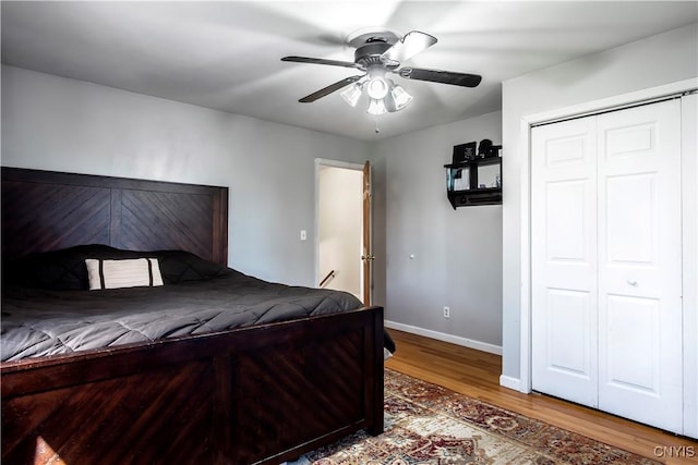 bedroom with wood finished floors, baseboards, a closet, and ceiling fan