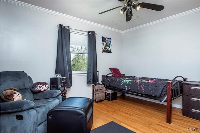 bedroom with wood finished floors, ornamental molding, and a ceiling fan