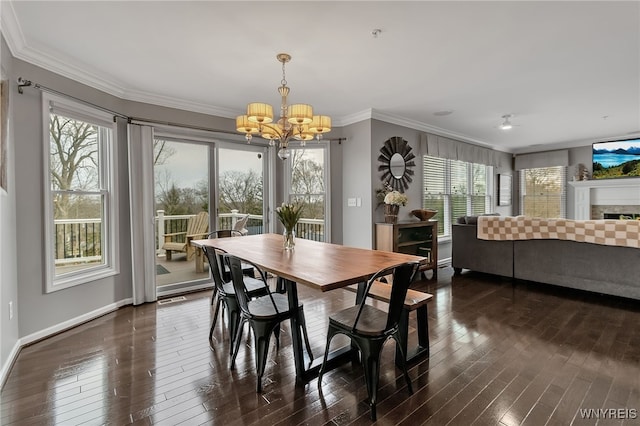 dining space with a chandelier, baseboards, dark wood-style floors, ornamental molding, and a fireplace