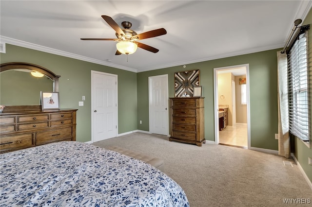 carpeted bedroom featuring ornamental molding, baseboards, a ceiling fan, and ensuite bath