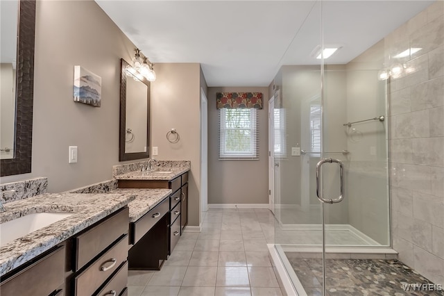 bathroom featuring a shower stall and two vanities