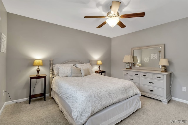 bedroom featuring light colored carpet, baseboards, and ceiling fan