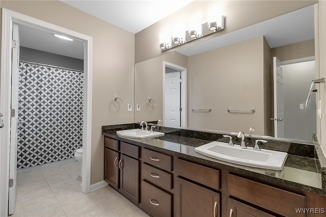 full bathroom with double vanity, toilet, baseboards, and a shower with curtain