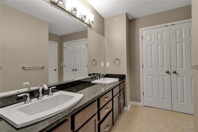 bathroom with tile patterned flooring, double vanity, and baseboards