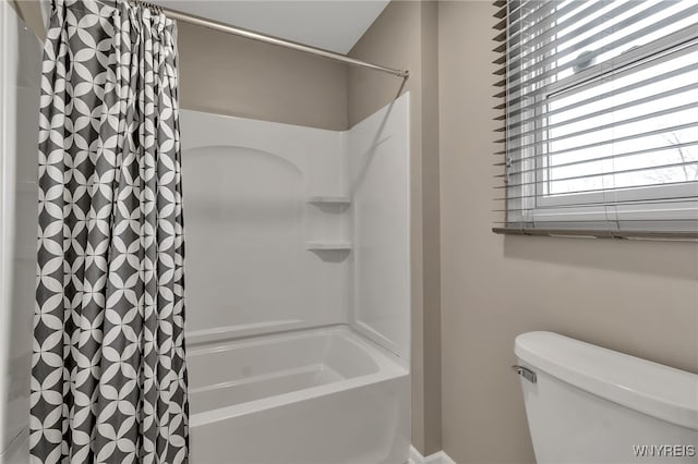 bathroom with toilet and shower / bath combo with shower curtain