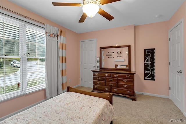 carpeted bedroom featuring baseboards and ceiling fan