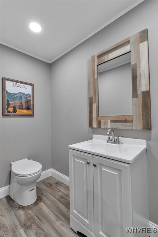 905 Sullivan Ct, Lewiston, NY 14092 - bathroom with wood finished floors, toilet, vanity, and baseboards