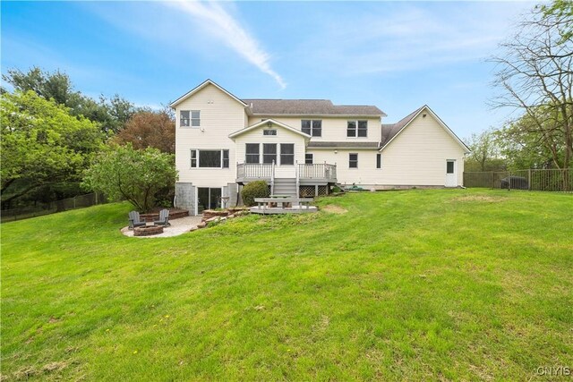 rear view of property featuring a fire pit and a wooden deck