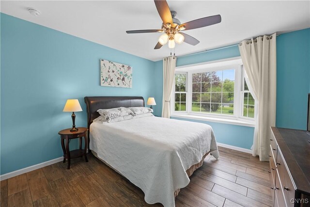 bedroom with baseboards, wood finished floors, and a ceiling fan