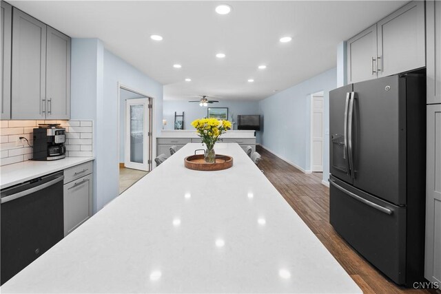 kitchen with stainless steel fridge, dishwashing machine, gray cabinetry, ceiling fan, and decorative backsplash