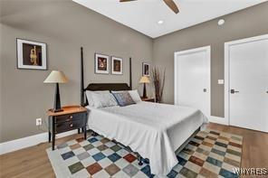 bedroom featuring wood finished floors, baseboards, and a ceiling fan