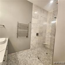 full bathroom with vanity and tiled shower