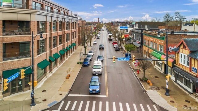 view of asphalt road featuring sidewalks, street lights, and curbs