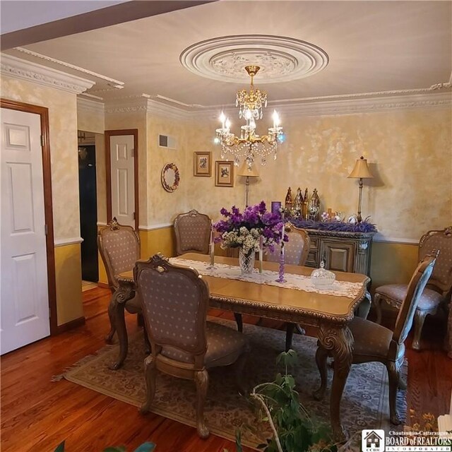 384 Flickerwood Rd, Kane-Borough, PA 16735 - dining area with wood finished floors, a chandelier, ornamental molding, and wallpapered walls