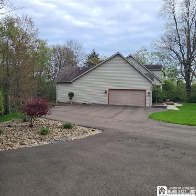 384 Flickerwood Rd, Kane-Borough, PA 16735 - view of side of property featuring asphalt driveway, an attached garage, and a yard