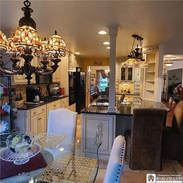 384 Flickerwood Rd, Kane-Borough, PA 16735 - kitchen with a chandelier, dark countertops, black refrigerator, cream cabinetry, and light tile patterned floors
