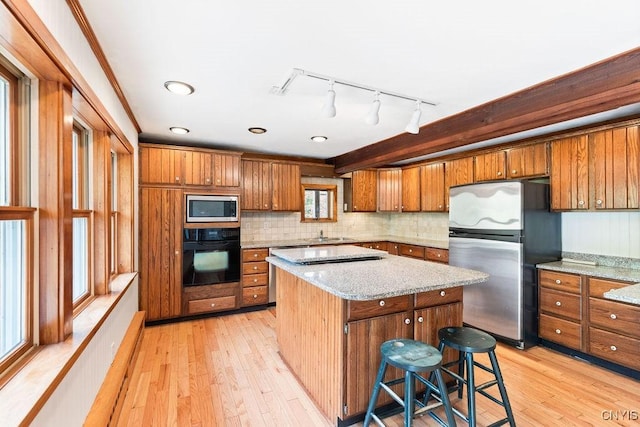 1826 Cardner Rd, Fabius, NY 13122 - kitchen with appliances with stainless steel finishes, brown cabinets, a kitchen island, and light wood finished floors