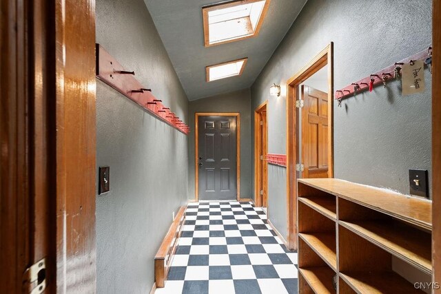 1826 Cardner Rd, Fabius, NY 13122 - hall with tile patterned floors, vaulted ceiling, a textured wall, and baseboards