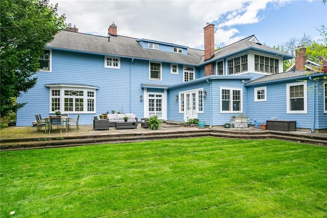back of property with an outdoor hangout area, a lawn, and a chimney
