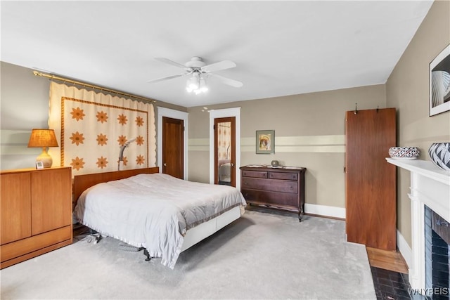 bedroom with a fireplace with flush hearth and a ceiling fan
