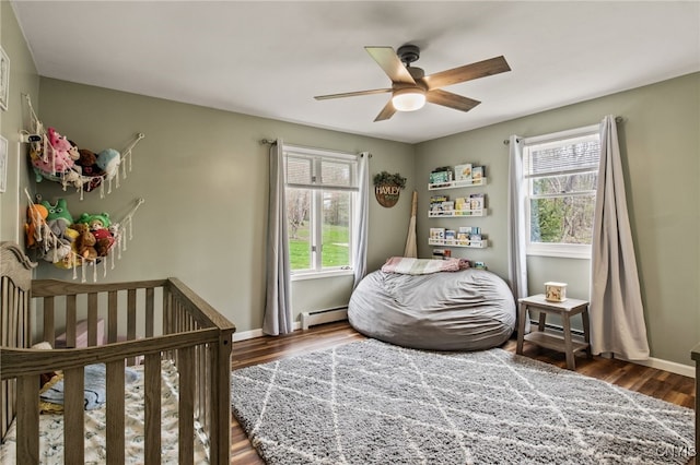 545 County Route 54, Schroeppel, NY 13132 - bedroom featuring a baseboard radiator, multiple windows, wood finished floors, and baseboards
