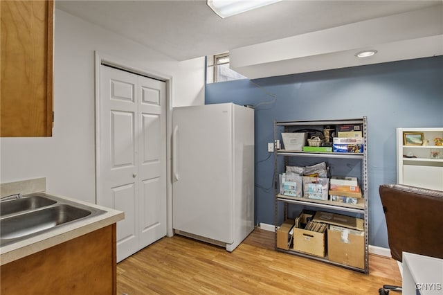 545 County Route 54, Schroeppel, NY 13132 - kitchen with freestanding refrigerator, a sink, light wood-style flooring, and light countertops
