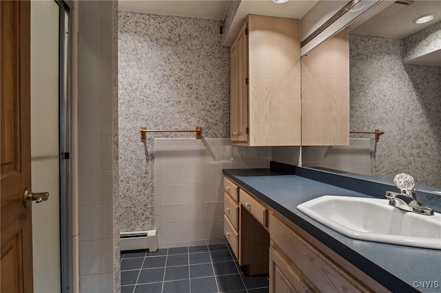 545 County Route 54, Schroeppel, NY 13132 - full bath with tile patterned floors, vanity, tile walls, a baseboard heating unit, and a shower with shower door