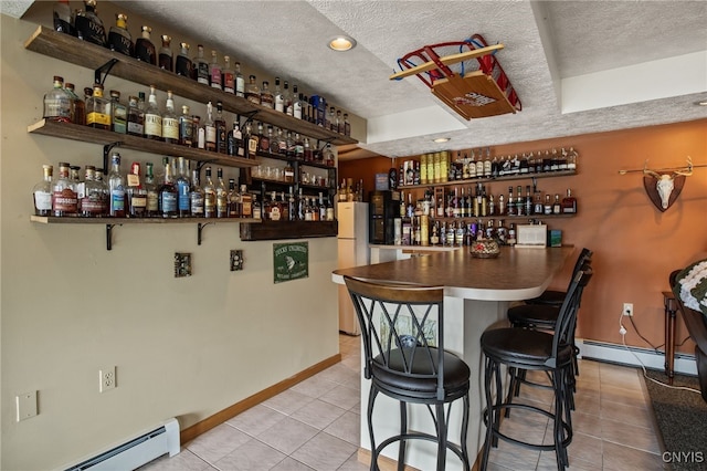 545 County Route 54, Schroeppel, NY 13132 - indoor dry bar with a baseboard heating unit, a textured ceiling, tile patterned floors, baseboards, and freestanding refrigerator