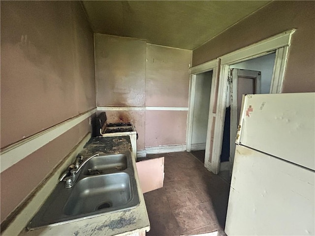 kitchen featuring freestanding refrigerator and a sink