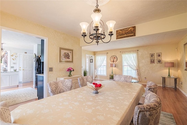 1430 Erie Station Rd, Henrietta, NY 14467 - dining room with wood finished floors, a chandelier, and baseboards