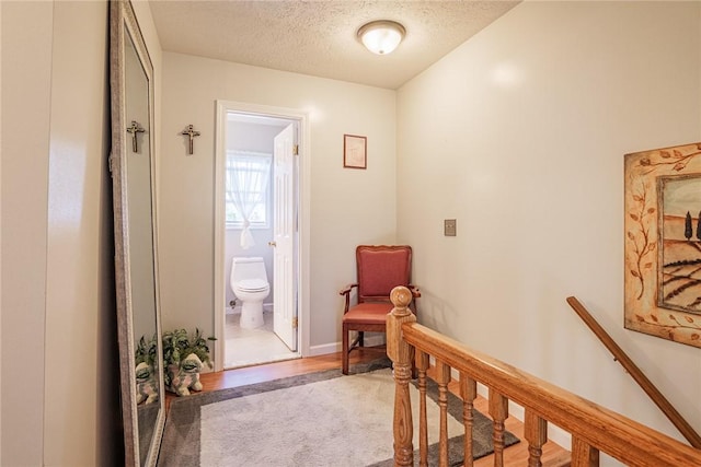 1430 Erie Station Rd, Henrietta, NY 14467 - hall with a textured ceiling, an upstairs landing, and wood finished floors