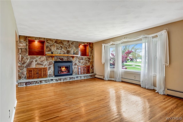 unfurnished living room featuring a baseboard radiator, wood finished floors, a fireplace, baseboard heating, and baseboards