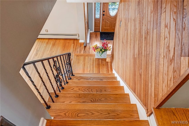 stairs with a baseboard radiator and wood finished floors