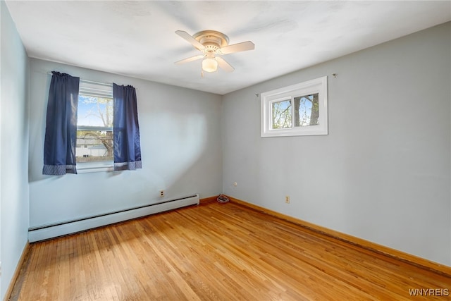 empty room featuring a baseboard radiator, wood finished floors, ceiling fan, and baseboards