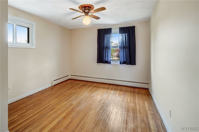 empty room with healthy amount of natural light, light wood finished floors, a ceiling fan, and a baseboard heating unit